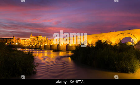 Beleuchtete Puente Romano, römische Brücke über Rio Guadalquivir, hinten Mezquita, Catedral de Córdoba, Abenddämmerung, Cordoba, Andalusien Stockfoto