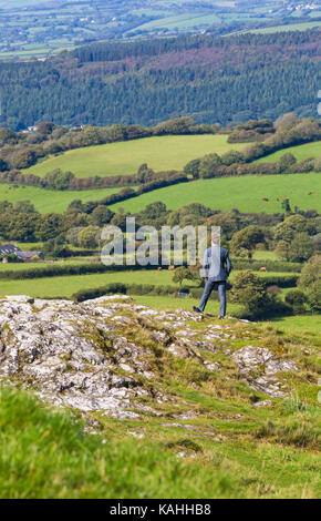 Mann stand auf felsvorsprung von Kirche St. Michael de Rupe, St. Michael der Felsen, an Brentor, Nationalpark Dartmoor, Devon, UK im September Stockfoto