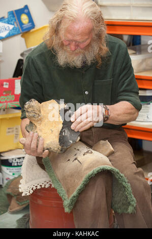 Feuerstein-Knapping-Demonstration, indem man lernt, mit Knochenwerkzeugen von Hand eine Pfeilspitze aus Feuerstein zu machen Stockfoto