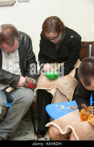 Feuerstein-Knapping-Demonstration, indem man lernt, mit Knochenwerkzeugen von Hand eine Pfeilspitze aus Feuerstein zu machen Stockfoto