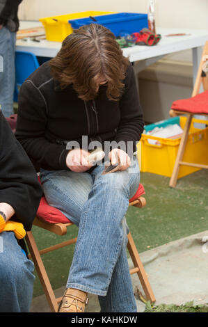 Feuerstein-Knapping-Demonstration, indem man lernt, mit Knochenwerkzeugen von Hand eine Pfeilspitze aus Feuerstein zu machen Stockfoto