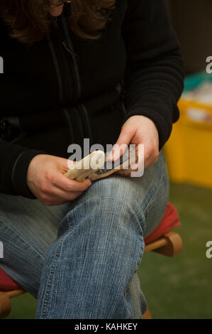 Feuerstein-Knapping-Demonstration, indem man lernt, mit Knochenwerkzeugen von Hand eine Pfeilspitze aus Feuerstein zu machen Stockfoto