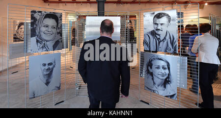 Besucher schauen Sie sich die Bilder in der Ausstellung "Von Mensch zu Mensch. Ich habe einen Namen" (Lit. Von Mensch zu Mensch. Ich habe einen Namen) an der Europaeisches Informations-Zentrum in Erfurt, Deutschland, 26. September 2017. Die Ausstellung zeigt Fotos und Geschichten von Flüchtlingen, die aus Syrien, Irak, Eritrea, Afghanistan, Palästina, Albanien und Kosovo nach Thüringen gekommen sind. Die Ausstellung läuft vom 26. September bis 20. Oktober. Foto: Martin Schutt/dpa-Zentralbild/dpa Stockfoto