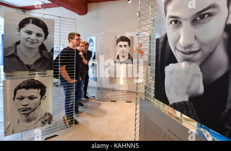 Besucher schauen Sie sich die Bilder in der Ausstellung "Von Mensch zu Mensch. Ich habe einen Namen" (Lit. Von Mensch zu Mensch. Ich habe einen Namen) an der Europaeisches Informations-Zentrum in Erfurt, Deutschland, 26. September 2017. Die Ausstellung zeigt Fotos und Geschichten von Flüchtlingen, die aus Syrien, Irak, Eritrea, Afghanistan, Palästina, Albanien und Kosovo nach Thüringen gekommen sind. Die Ausstellung läuft vom 26. September bis 20. Oktober. Foto: Martin Schutt/dpa-Zentralbild/dpa Stockfoto