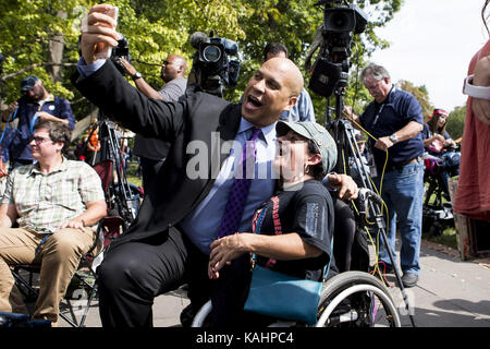 September 26, 2017 - Washington, District of Columbia, USA - Senator Cory Booker (D-NJ) stellt für eine selfie mit einem Health Care Demonstrant in einem Rollstuhl nach einer Pressekonferenz außerhalb des United States Capitol Building. (Bild: © Alex Edelman über ZUMA Draht) Stockfoto