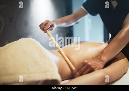 Masseur mit Massage Bambus Stockfoto