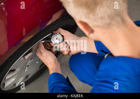 Nahaufnahme der Mechaniker prüfen Luftdruck im Reifen Stockfoto