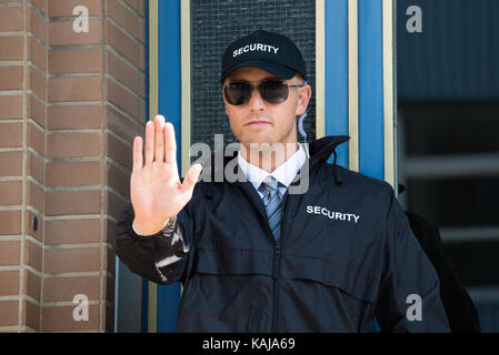 Nahaufnahme eines männlichen Security Guard, Stop-Schild mit Sonnenbrille tragen Stockfoto
