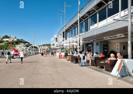 Touristen im Freien Speisen von der Marina am Beacon Quay Torquay Devon mit Blick auf Fluchtpunkt Skulptur im Hintergrund genießen. Stockfoto