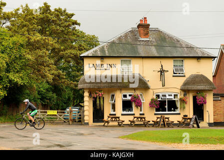 Ein Radfahrer vorbei das Lamb Inn, Nomansland, Wiltshire. Stockfoto