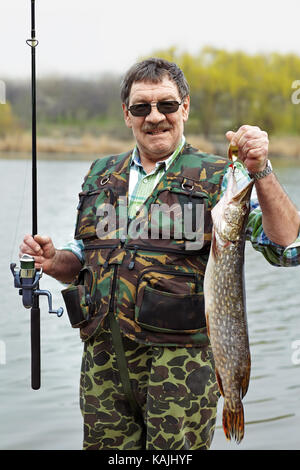 Porträt eines reifen Fischer mit seinen Fang neben dem Fluss Stockfoto