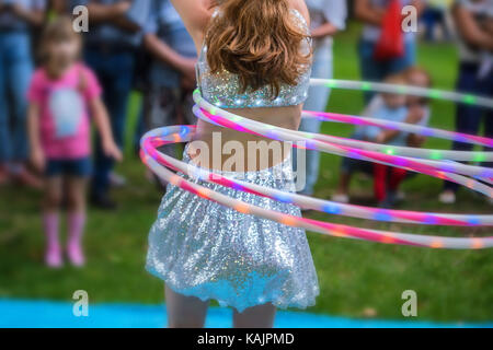 Mädchen in schönen Kleid spielt mit Hula Hoop Stockfoto