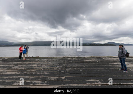 Tourist in Luss Pier, am Westufer von Loch Lomond, Argyll & Bute, Schottland, Großbritannien Stockfoto