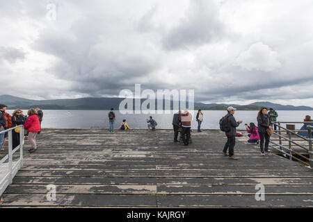 Tourist in Luss Pier, am Westufer von Loch Lomond, Argyll & Bute, Schottland, Großbritannien Stockfoto