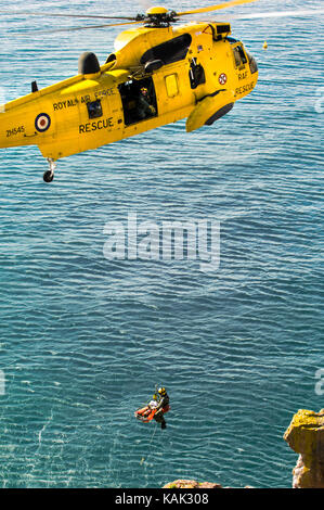 Tatsächliche Cliff Rettung durch RAF Suche und Rettung Sea King Helicoter am Meadfoot Beach, Torquay, Devon, Großbritannien Stockfoto