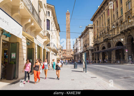 Leute, die in der 'Via Rizzoli' eine der wichtigsten Straße im historischen Zentrum von Bologna Stadt mit Blick auf den Asinelli Turm. Emilia-Romagna Regio Stockfoto