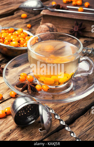 Schale mit heilenden Tee mit Beeren Sanddorn auf hölzernen retro Hintergrund Stockfoto