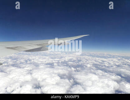 Meer der Wolken unter dem flugzeugflügel wie aus dem Flugzeug Fenster während des Fluges gesehen Stockfoto