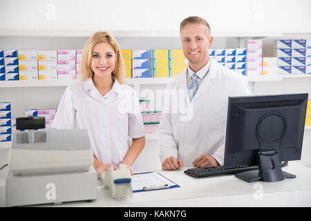 Portrait von männlichen und weiblichen Apotheker am Zähler lächelnd in der Pharmazie Stockfoto