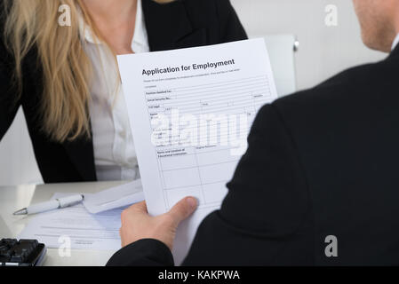 Männliche Bewerber holding Antrag vor der Interviewer im Büro Stockfoto