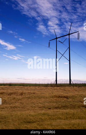 Ein Holz Hochspannungsleitung auf einem strahlend blauen Himmel. Stockfoto