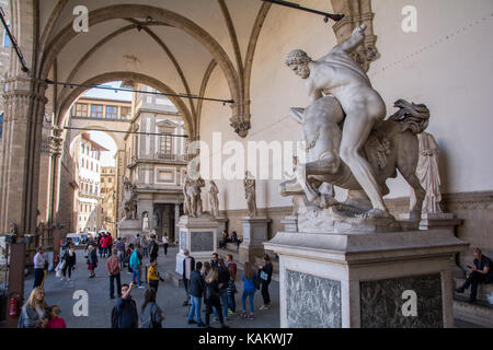 Touristen bewundern die verschiedenen Marmor Statuen an der Loggia dei Lanzi in Florenz, Italien Stockfoto