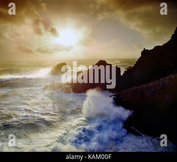 Kanal Inseln. Guernsey. Pleinmont Punkt. Auf den Felsen bei Sonnenuntergang Surfen. Stockfoto