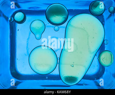 Detail von Öl Blasen im Wasser auf blauem Hintergrund Stockfoto
