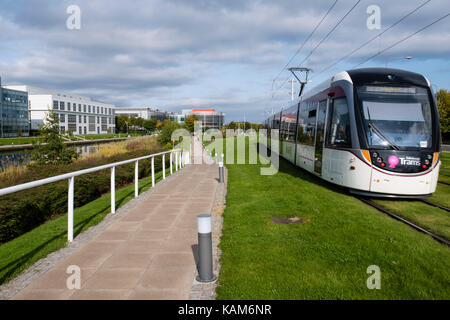 Die Straßenbahn fährt durch Edinburgh Park ein modernes Business Park South Gyle in Edinburgh, Schottland, Vereinigtes Königreich. Stockfoto