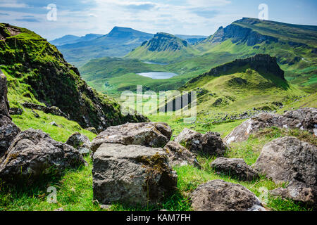 Ein Blick auf die Landschaft der Insel Skye von der Quiraing mit großen Felsbrocken im Vordergrund. Stockfoto