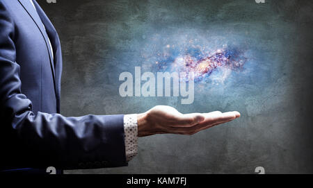 Geschäftsmann Hand kleine Galaxie. Stockfoto