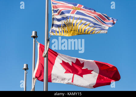 Kanada und British Columbia Flaggen über blauen Himmel in Vancouver, BC, Kanada winken Stockfoto