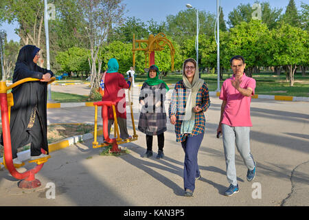 Provinz Fars, Shiraz, Iran - 19. April 2017: Sportplatz im Freien, kostenlosen Fitnessgeräte, muslimische Frauen in hijabs tun morgen Übung. Stockfoto