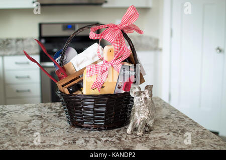 Ein Haus Erwärmung Korb voller Küche Zubehör auf der Küchenarbeitsplatte. Stockfoto