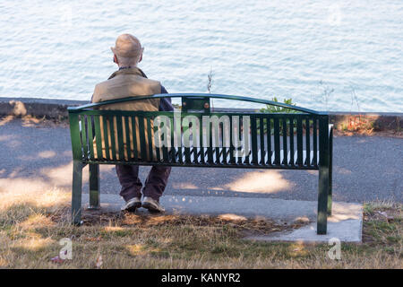 Victoria, BC, Kanada - 11 September 2017: älterer Mann auf einer Bank sitzen auf David Weise fördern. Stockfoto