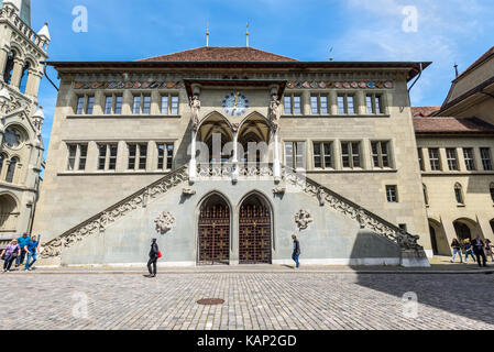 Bern, Schweiz - 26. Mai 2016: Fassade des alten Rathauses in Bern, Schweiz, Weltkulturerbe der UNESCO. Die Menschen auf der Straße. Stockfoto