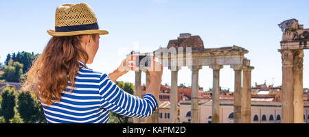 Roman Holiday. Moderne touristische Frau in der Vorderseite des Forum Romanum in Rom, Italien mit Digitalkamera, Foto Stockfoto