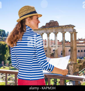 Urlaub in Rom. Hinter der eleganten Frau gegen Forum Romanum in Rom, Italien, mit Karte gesehen Stockfoto