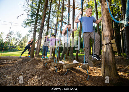 Mitarbeiter Kreuzung Swinging Logs im Wald Stockfoto