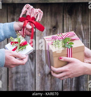 Romantisches Paar den Austausch von Geschenken in einer rustikalen Umgebung Stockfoto
