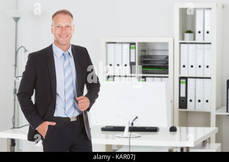 Portrait von selbstbewussten jungen Geschäftsmann im Büro Stockfoto
