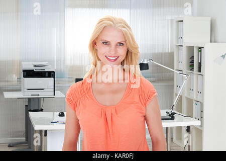 Portrait von schönen jungen Geschäftsfrau lächelnd im Büro Stockfoto