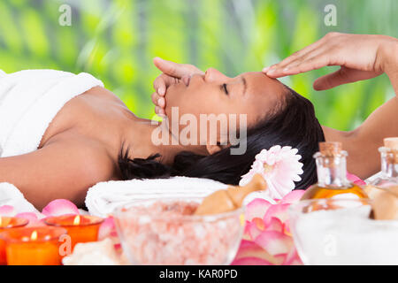 Seitenansicht der jungen Frau empfangen Kopf Massage Massagegerät in Beauty Spa Stockfoto