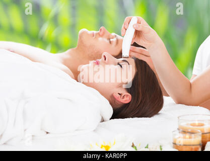 Seitenansicht des entspannt junges paar Therapien, die sich auf Beauty Spa Stockfoto