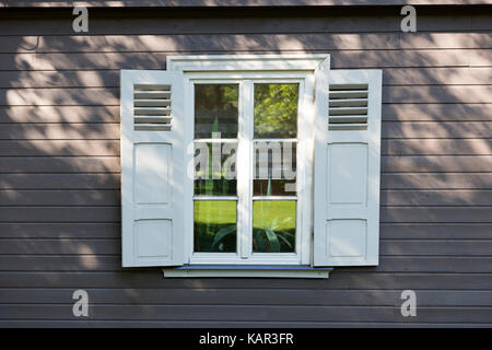 Kleine Vintage White Fenster mit Fensterläden auf Holz graue Wand Stockfoto
