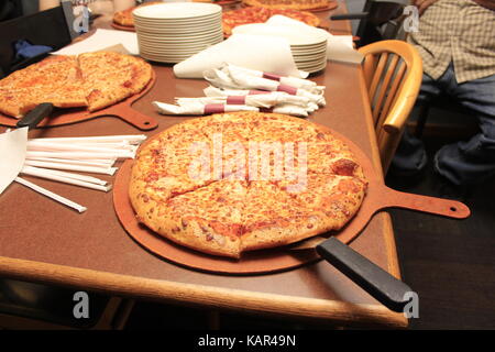 Pizza in der Nähe auf einem Tisch Stockfoto