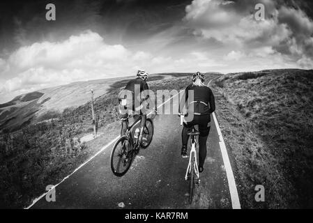 Radfahren Paar klettern Große Dun fiel in den Pennines, Cumbria, Großbritannien Stockfoto