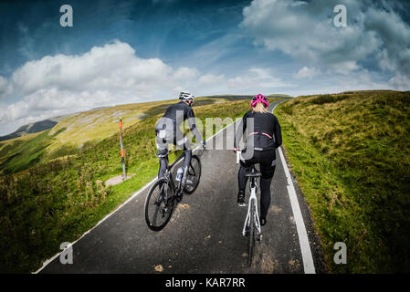 Radfahren Paar klettern Große Dun fiel in den Pennines, Cumbria, Großbritannien Stockfoto