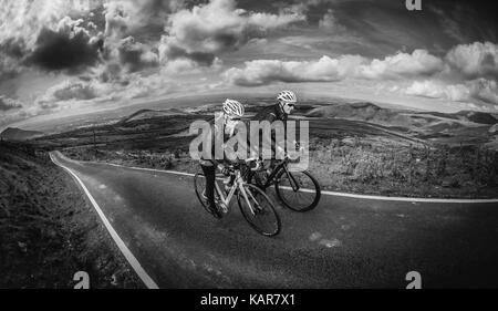 Radfahren Paar klettern Große Dun fiel in den Pennines, Cumbria, Großbritannien Stockfoto