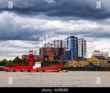 London, Rot Leuchtturm Boot, Caroline auf der Themse und London City Island, neue Gebäude, in dem der Entwicklung von Ballymore Group. schwarze Gewitterwolken. Stockfoto